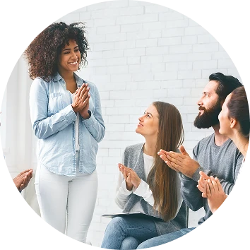 Group members applauding and encouraging a participant during a supportive group session, promoting confidence, recognition, and personal growth.